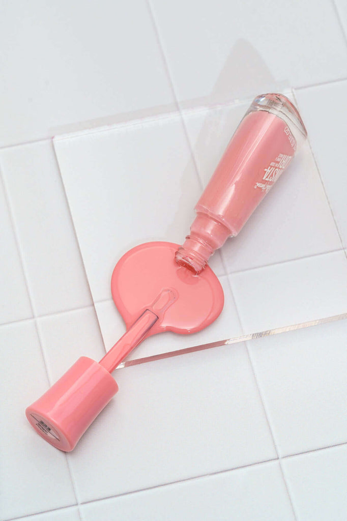 Acrylic riser tile prop with pink spilled nail varnish on top