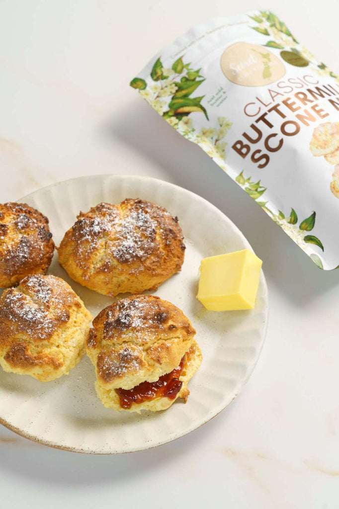 Butter scones on a plate with a packet of scone mix in the background on a backdrop from CM Props & Backdrops 