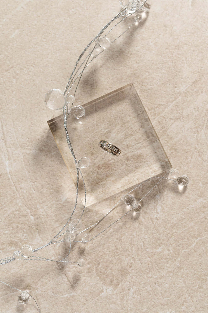 Square-shaped acrylic riser photo prop on a stone backdrop