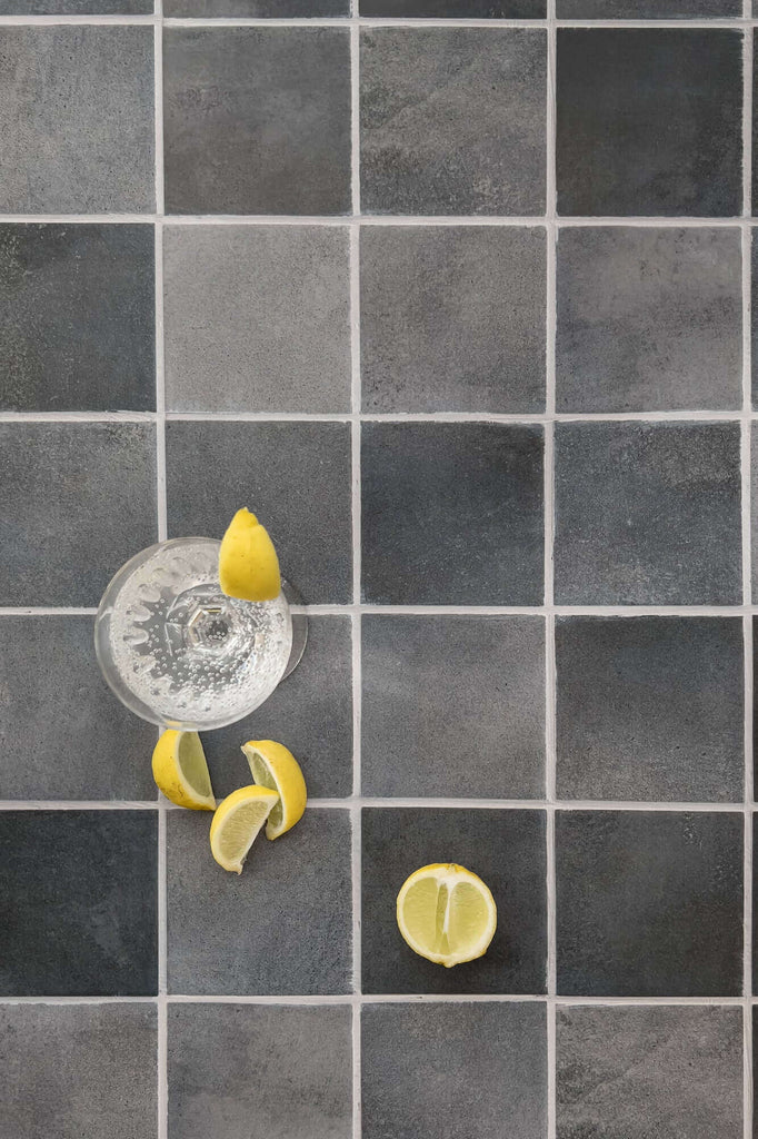 Food photo of glass and yellow limes on grey slate tiles, vinyl backdrop, CM Props & Backdrops